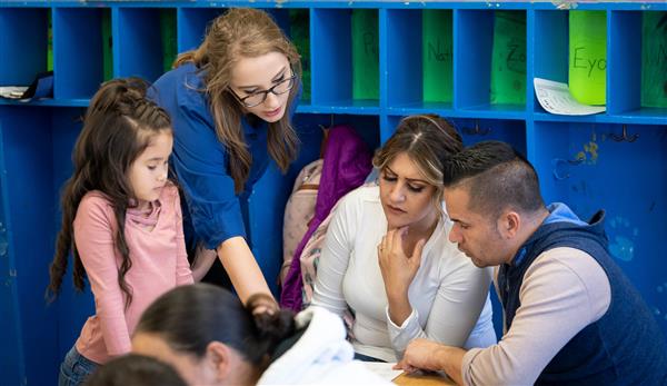 Parents and teacher working together in classroom.